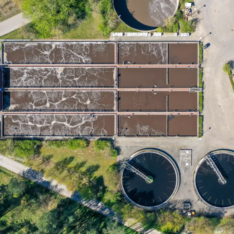 Vista aérea de una planta de tratamiento de agua con piscinas y tanques industriales, ilustrando la infraestructura de las desaladoras en el sector minero.